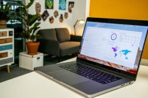 Laptop on a desk in an office with Social Media Analytics Stats on the screen