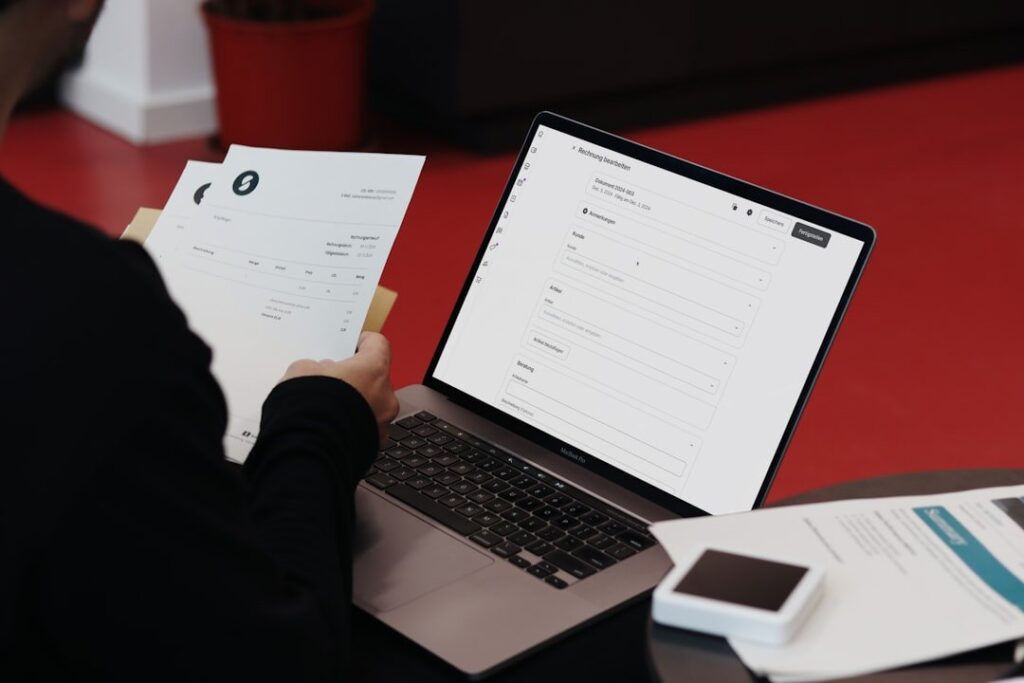 A person balancing traditional documents with an online invoice system. SumUp combines convenience and efficiency for businesses.
